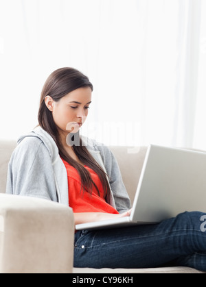 Woman using her laptop as she sits on the couch Stock Photo