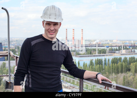 Young handsome man constructor in white helmet on altitude Stock Photo