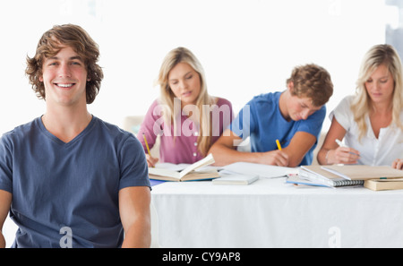 A young man sitting in front of his working class mates Stock Photo