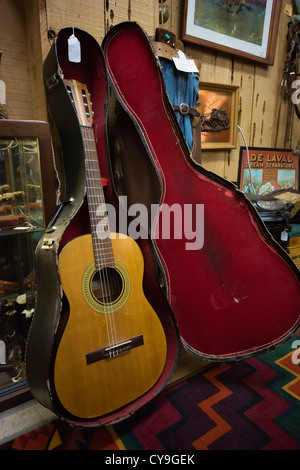 Jamestown, California - historic goldrush township near the 'motherlode' mines. 1962 Gibson guitar for sale in a junk shop. Stock Photo