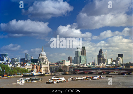 City of London and River Thames viewed from Waterloo Bridge with restaurant boat navigating downstream London UK