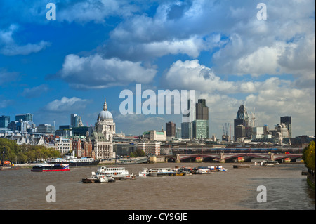 City of London and River Thames viewed from Waterloo Bridge with restaurant boat navigating downstream London UK
