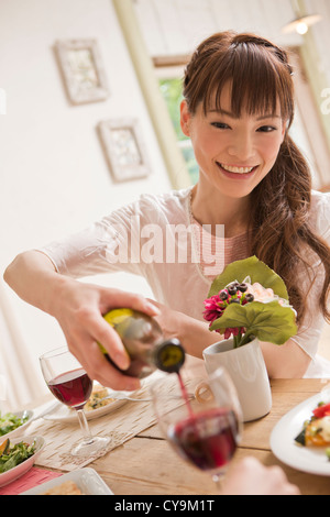 Black woman pouring glass of red wine Stock Photo - Alamy