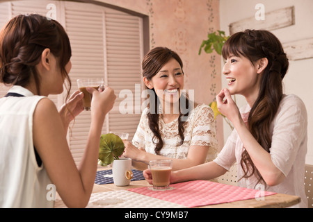 Three Young Women Enjoying Coffee Stock Photo