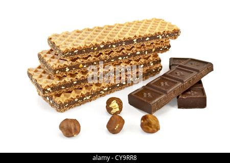 A stack of waffles, interlayered with chocolate, two bars of chocolate and four nuts isolated on white background Stock Photo