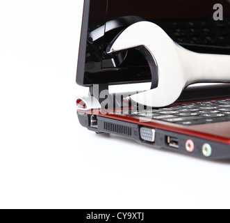 computer supports concept: wrench lying on the laptop on the white background Stock Photo