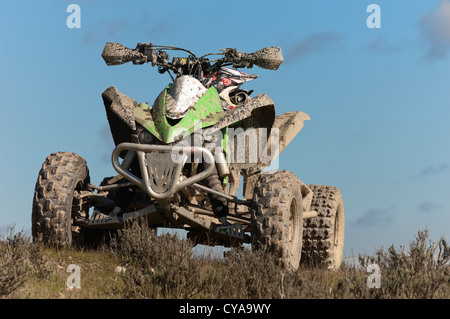 Muddy quad bike view from below left alone on a hill Stock Photo