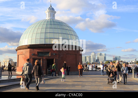 Greenwich Foot Tunnel entrance, with Canary Wharf and the Docklands in the distance behind, in the late Autumn sunshine, London Stock Photo