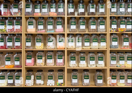 Jars of confectionery sit on shelves in neat rows in traditional sweet shop in Keswick, Lake District. Stock Photo