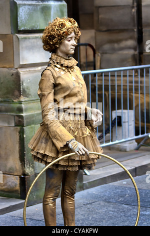 Woman entertainer, with a hoop, painted gold, in Victorian dress,Edinburgh, Scotland Stock Photo
