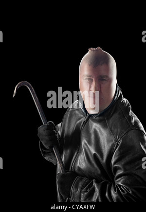 A criminal wearing pantyhose over his head to hide his identity carries a crowbar to commit a crime. Stock Photo