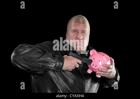 A masked thief threatening to shoot a piggy bank as he steals it during a bad economy. Stock Photo