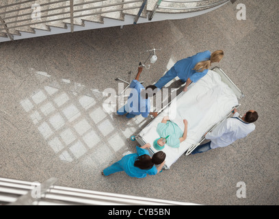 Three nurses and one doctor pushing a patient in a gurney Stock Photo