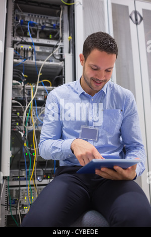Technician using tablet pc to work on servers Stock Photo