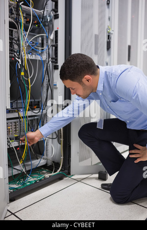 Man plugging a cable into server Stock Photo