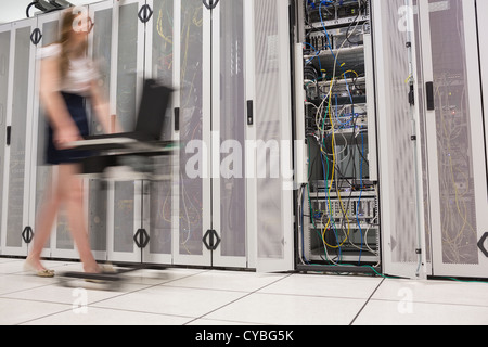 Woman pushing computer through data center Stock Photo