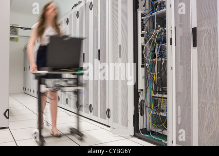 Woman pushing computer to open servers Stock Photo