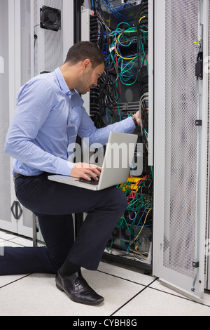 Man fixing wires while doing maintenance in data center Stock Photo