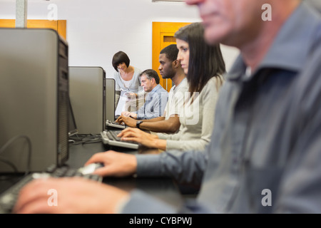 Teacher helping her students in computer class Stock Photo