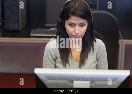 Black-haired woman concentrating on computer Stock Photo