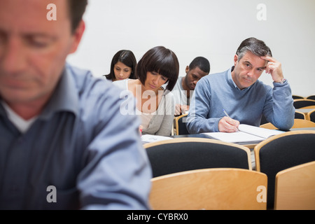 Man looking up from taking notes Stock Photo