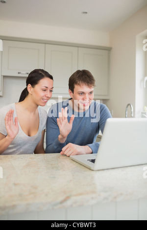 Smiling couple using video chat on laptop Stock Photo