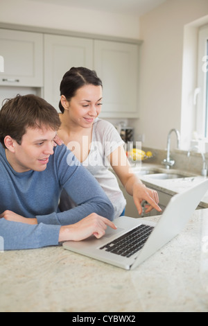 Happy couple looking at laptop Stock Photo