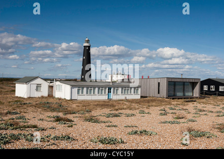 The old lighthouse and a mix of modern and older single-storey houses on the beach at Dungeness in Kent. Stock Photo