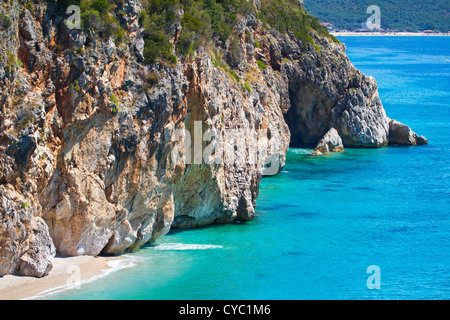 Beautiful sunny beach surrounded by high cliff wall Stock Photo