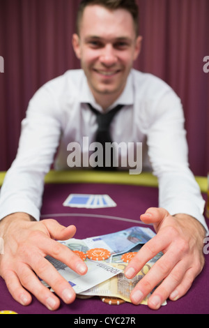 Man grabbing money at poker table Stock Photo