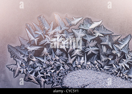 Delicate Winter Frost Patterns formed on a Glass Window Pane Stock Photo
