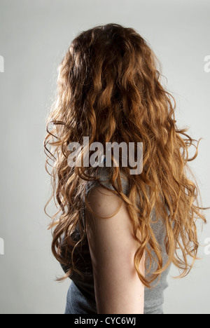Head and shoulders portrait of woman with back turned, long red hair Stock Photo