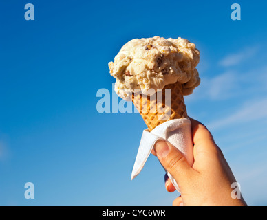 Icecream cone held up to the hot summer sky Stock Photo
