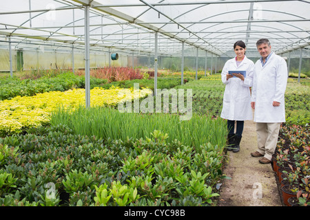 Greenhouse workers standing with tablet pc Stock Photo