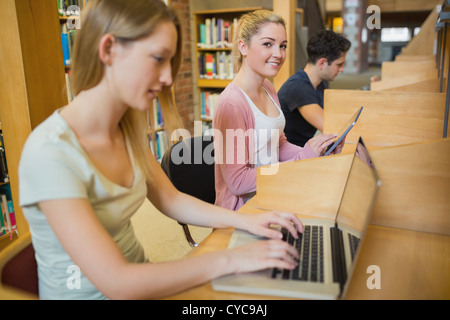 Woman using tablet pc looking up from studying Stock Photo