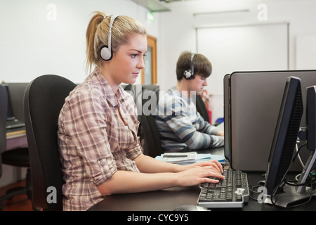 Student working in computer class wearing headphones Stock Photo