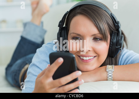 Woman using her smartphone and listening to music Stock Photo