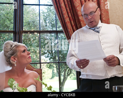 The bride becomes emotional during her father's speech at the wedding reception. Stock Photo