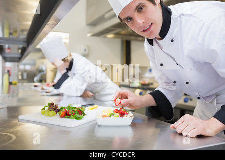 Happy chef preparing a fruit salad Stock Photo