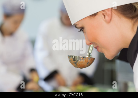Smiling chef smelling the soup