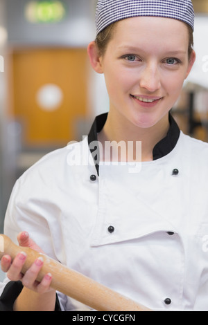 Woman holding rolling pin while smiling Stock Photo
