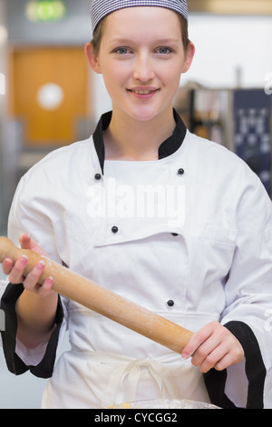 Smiling chef holding rolling pin Stock Photo