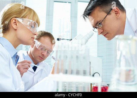 Group of clinicians experimenting with new substance in laboratory Stock Photo