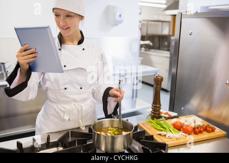 Female chef using tablet pc while cooking Stock Photo