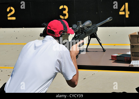 Gunman test firing .338 sniper rifle at the FBI shooting range in Chicago, Illinois, USA. Identity concealed by request. Stock Photo