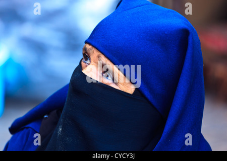 Portrait of Moroccan woman with bright blue traditional head covering in a Souk street market Marrakesh, Morocco. Stock Photo