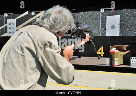 Gunman test firing .338 sniper rifle at the FBI shooting range in Chicago, Illinois, USA. Identity concealed by request. Stock Photo