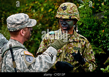 Aibano Training Area, Japan – Sgt. Craig D. Davis, from Medford, N.J., a team leader with Company B, 1st Battalion, 14th Infantry Regiment based at Schofield Barracks, Hawaii, communicates with an officer of the Japan Ground Self Defense Force during Orie Stock Photo