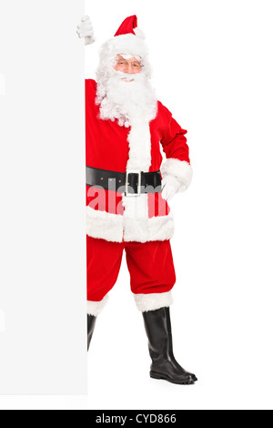 Full length portrait of a Santa Claus posing next to a blank billboard isolated on white background Stock Photo