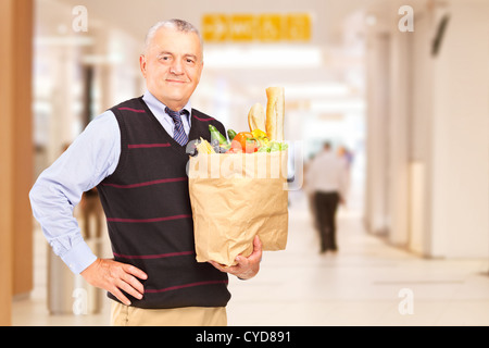 Gentleman in a shopping mall holding a bag with groceries Stock Photo